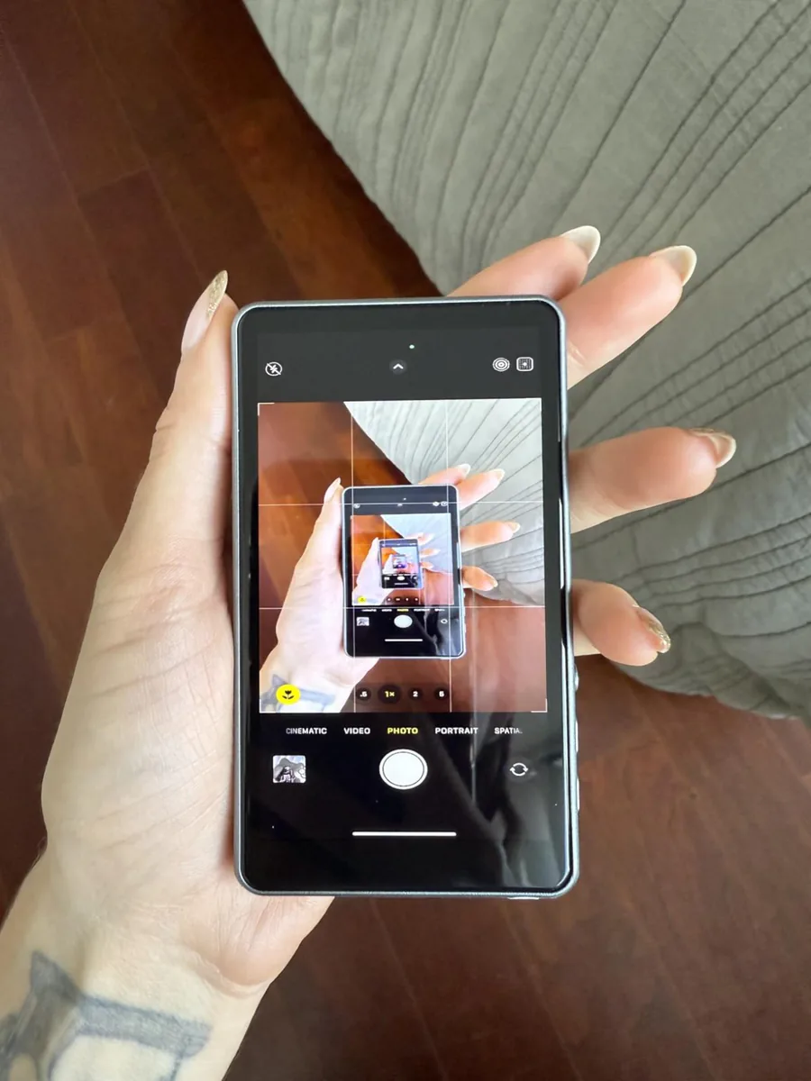 Mano sosteniendo la pantalla para selfies que muestra la imagen de la cámara