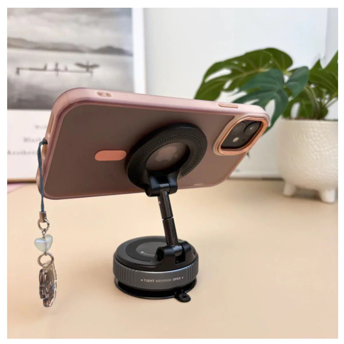 Celular con funda rosada sujeto al soporte magnético sobre una mesa