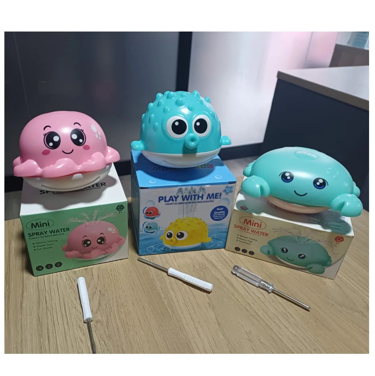 Pulpo rosado, pez globo azul y cangrejo verde de baño sobre sus cajas