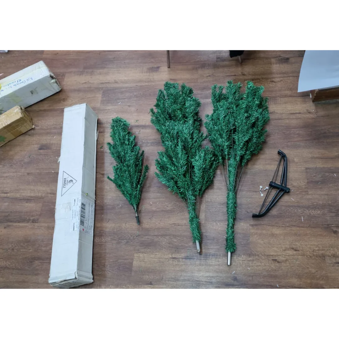 Las 3 secciones del árbol de Navidad, la base metálica y su caja en el piso