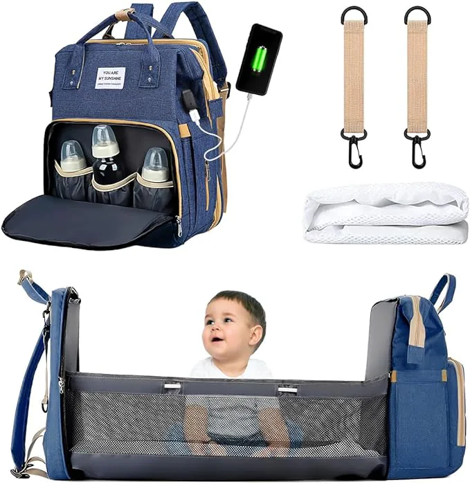 Morral pañalera azul con teteros, puerto USB, ganchos, colchoneta y la cuna abierta con un bebé