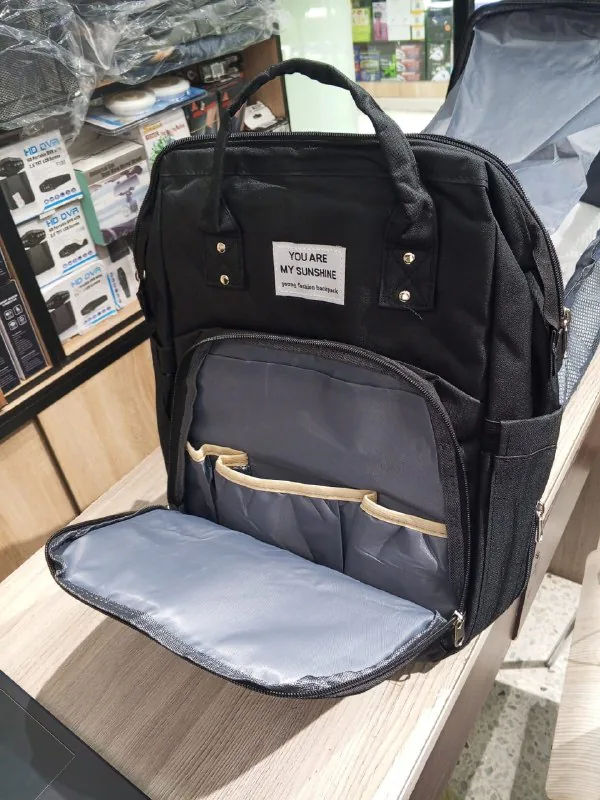 Morral pañalera negro con el bolsillo frontal abierto y sus compartimentos