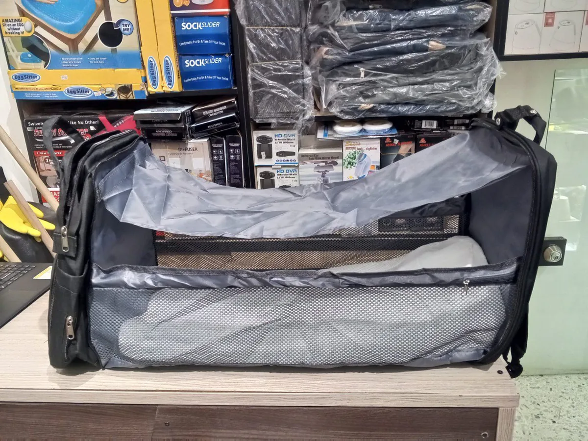 Morral pañalera negro abierto como cuna plegable con malla