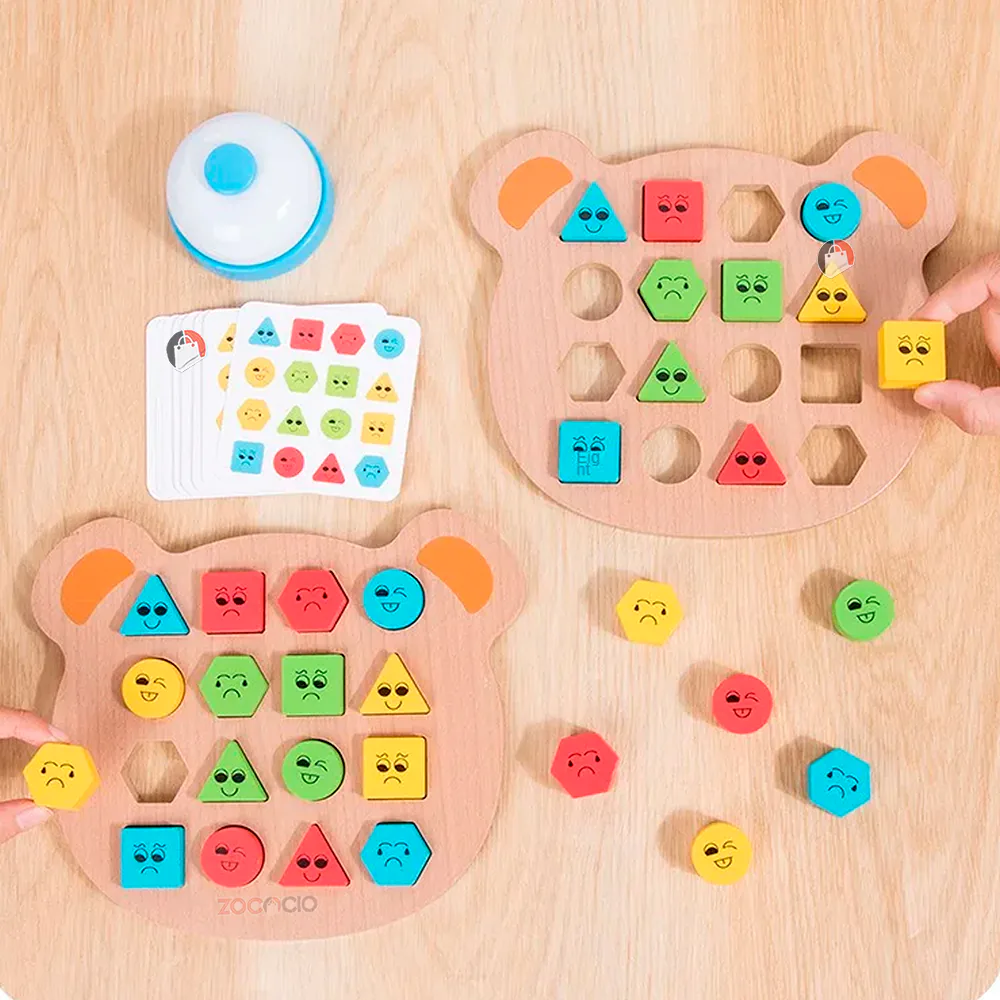 Manos armando los tableros de oso con bloques de colores junto al timbre y las tarjetas